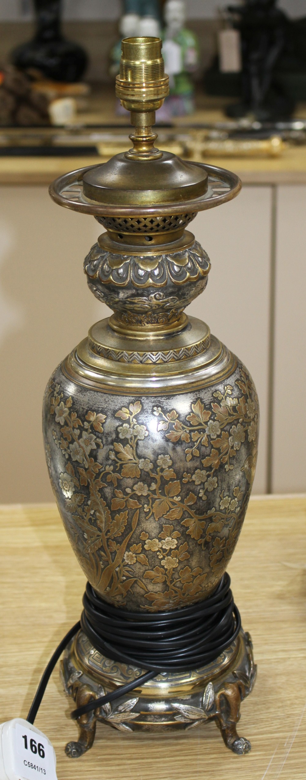 A 19th century French silvered and gilt brass table lamp, decorated with Oriental style flowers, scrolls and bamboo feet, overall heigh